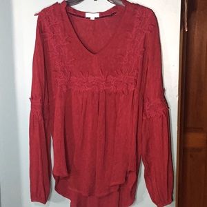 A dark red blouse with floral details